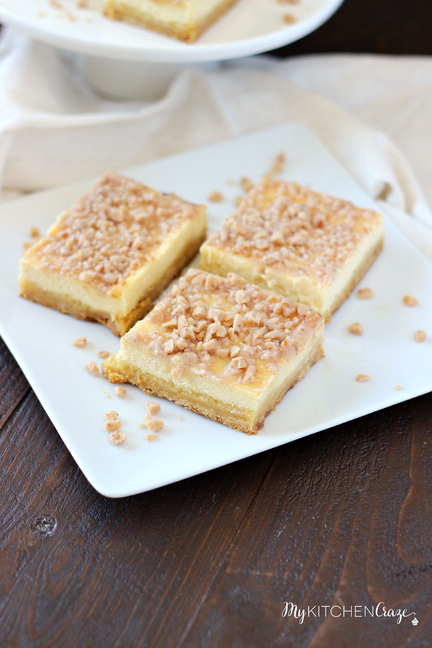 Toffee Cheesecake Bars ~ mykitchencraze ~ These bars are not only easy to throw together, but taste amazing! Sugar cookie bottom. Topped with a creamy cheesecake and sprinkled with toffee bits. What more could you ask for?