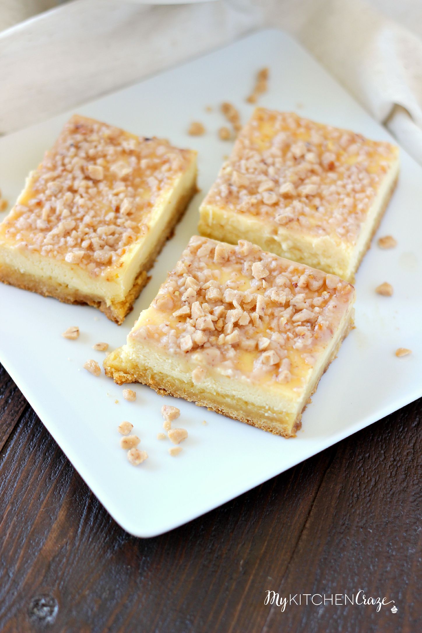 Toffee Cheesecake Bars ~ mykitchencraze ~ These bars are not only easy to throw together, but taste amazing! Sugar cookie bottom. Topped with a creamy cheesecake and sprinkled with toffee bits. What more could you ask for?