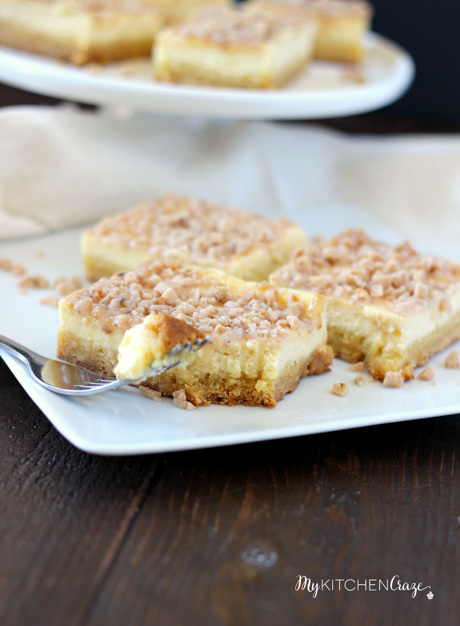 Toffee Cheesecake Bars ~ mykitchencraze ~ These bars are not only easy to throw together, but taste amazing! Sugar cookie bottom. Topped with a creamy cheesecake and sprinkled with toffee bits. What more could you ask for?