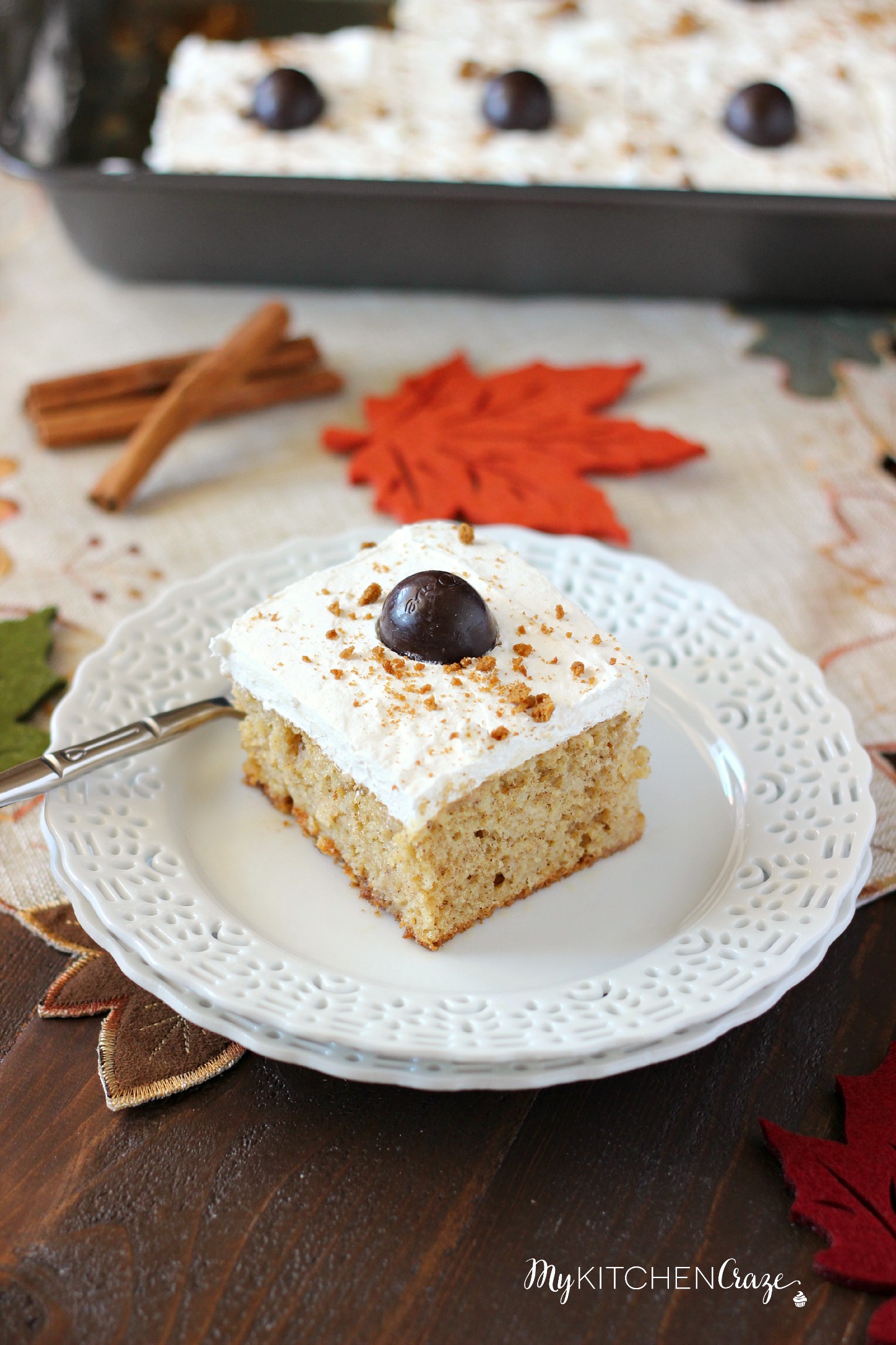 Spiced Pumpkin Poke Cake ~ mykitchencraze.com ~ Moist spiced pumpkin cake smothered with condensed milk, then topped with a cream cheese whipped frosting and a dark chocolate pumpkin. Delicious!