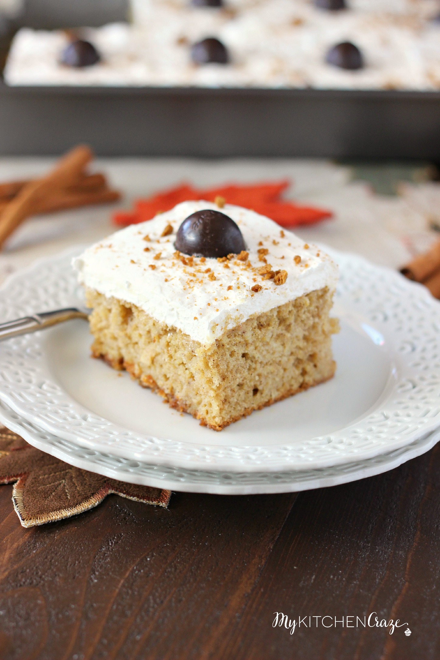 Spiced Pumpkin Poke Cake ~ mykitchencraze.com ~ Moist spiced pumpkin cake smothered with condensed milk, then topped with a cream cheese whipped frosting and a dark chocolate pumpkin. Delicious!