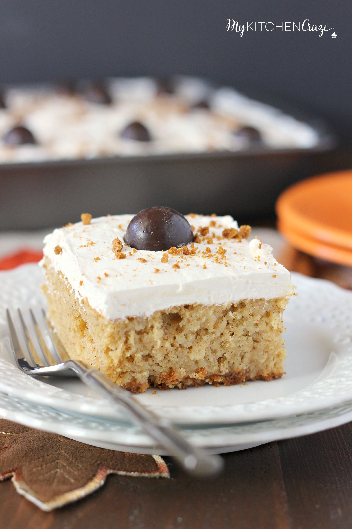 Spiced Pumpkin Poke Cake ~ mykitchencraze.com ~ Moist spiced pumpkin cake smothered with condensed milk, then topped with a cream cheese whipped frosting and a dark chocolate pumpkin. Delicious!