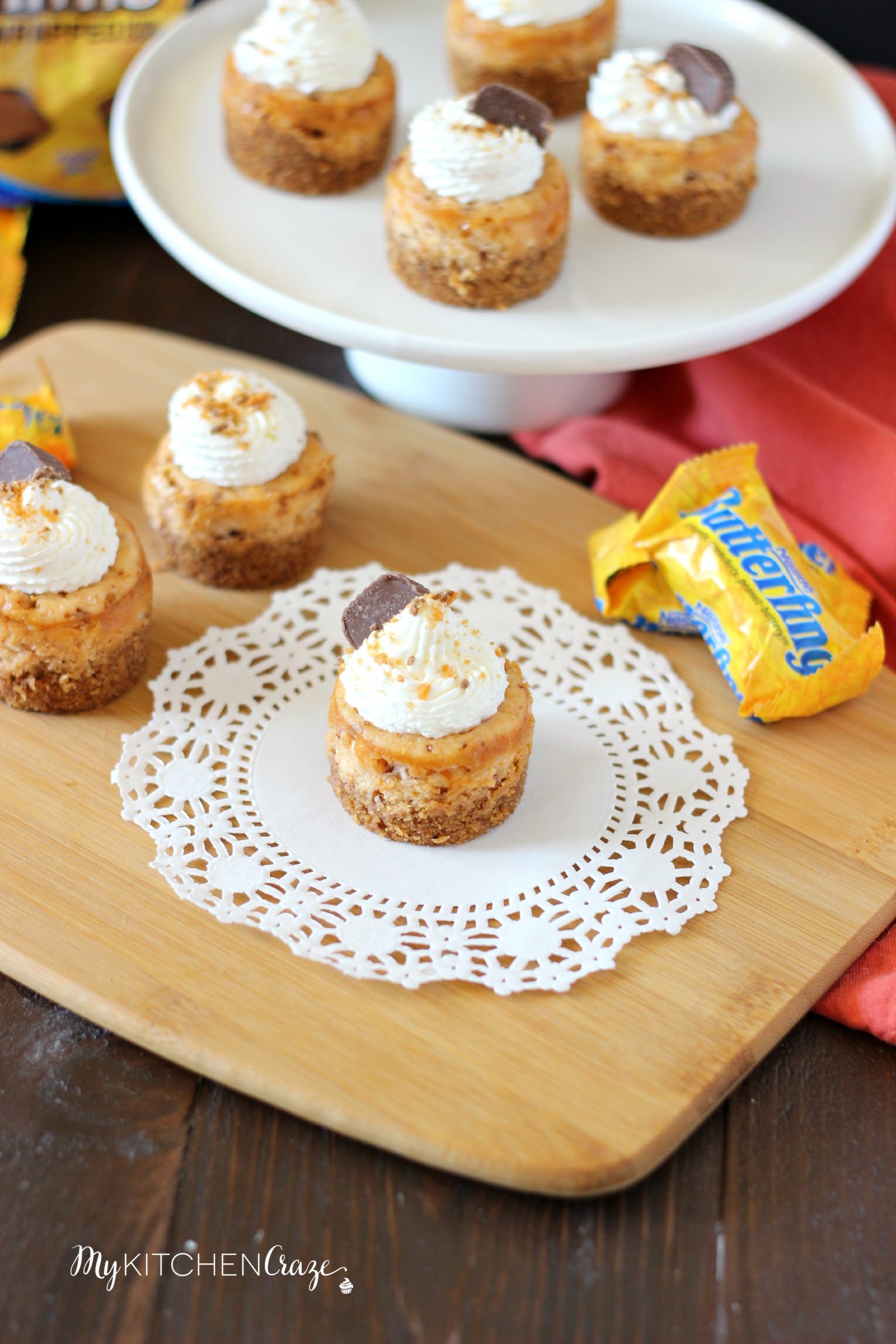 Mini Butterfinger Cheesecakes ~ mykitchencraze.com ~ Delicious cheesecakes swirled with butterfingers candies and topped with whipped cream! Yum!