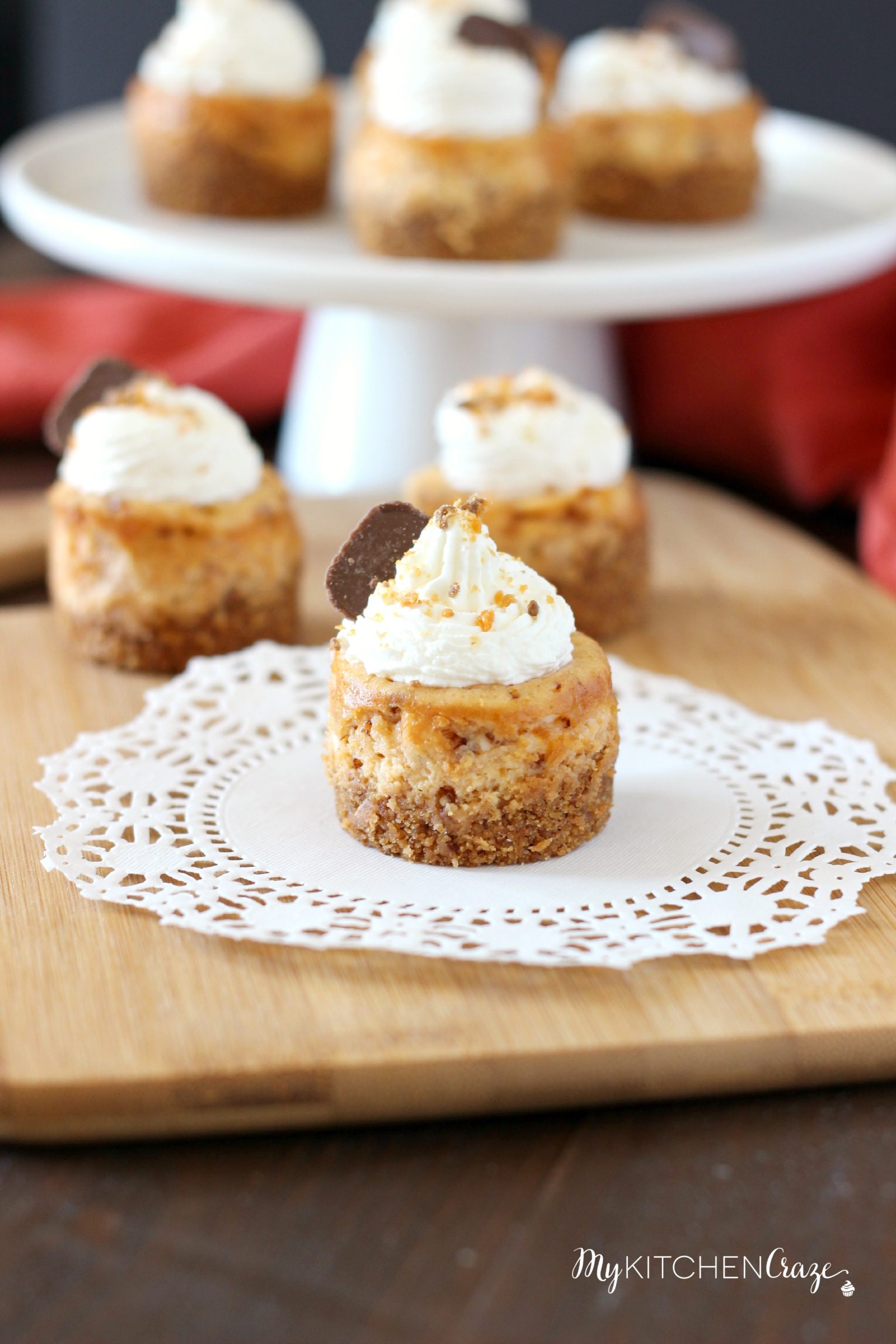 Mini Butterfinger Cheesecakes ~ mykitchencraze.com ~ Delicious cheesecakes swirled with butterfingers candies and topped with whipped cream! Yum!