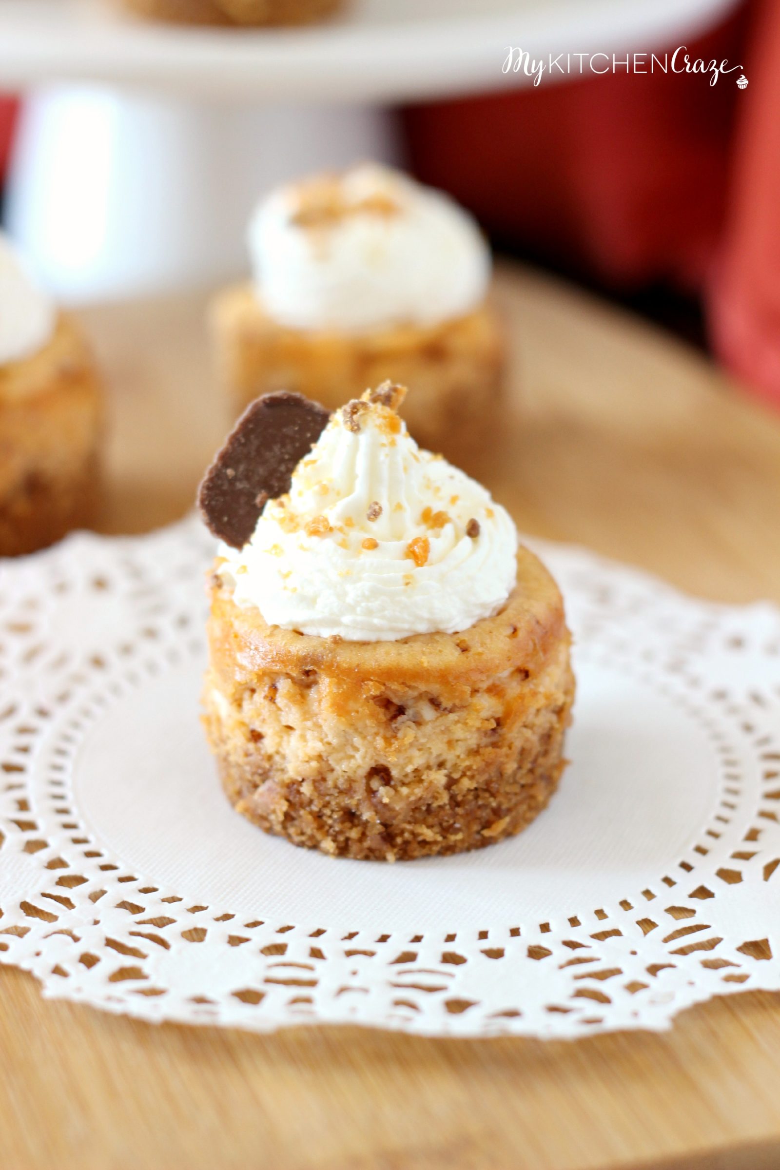 Mini Butterfinger Cheesecakes ~ mykitchencraze.com ~ Delicious cheesecakes swirled with butterfingers candies and topped with whipped cream! Yum!