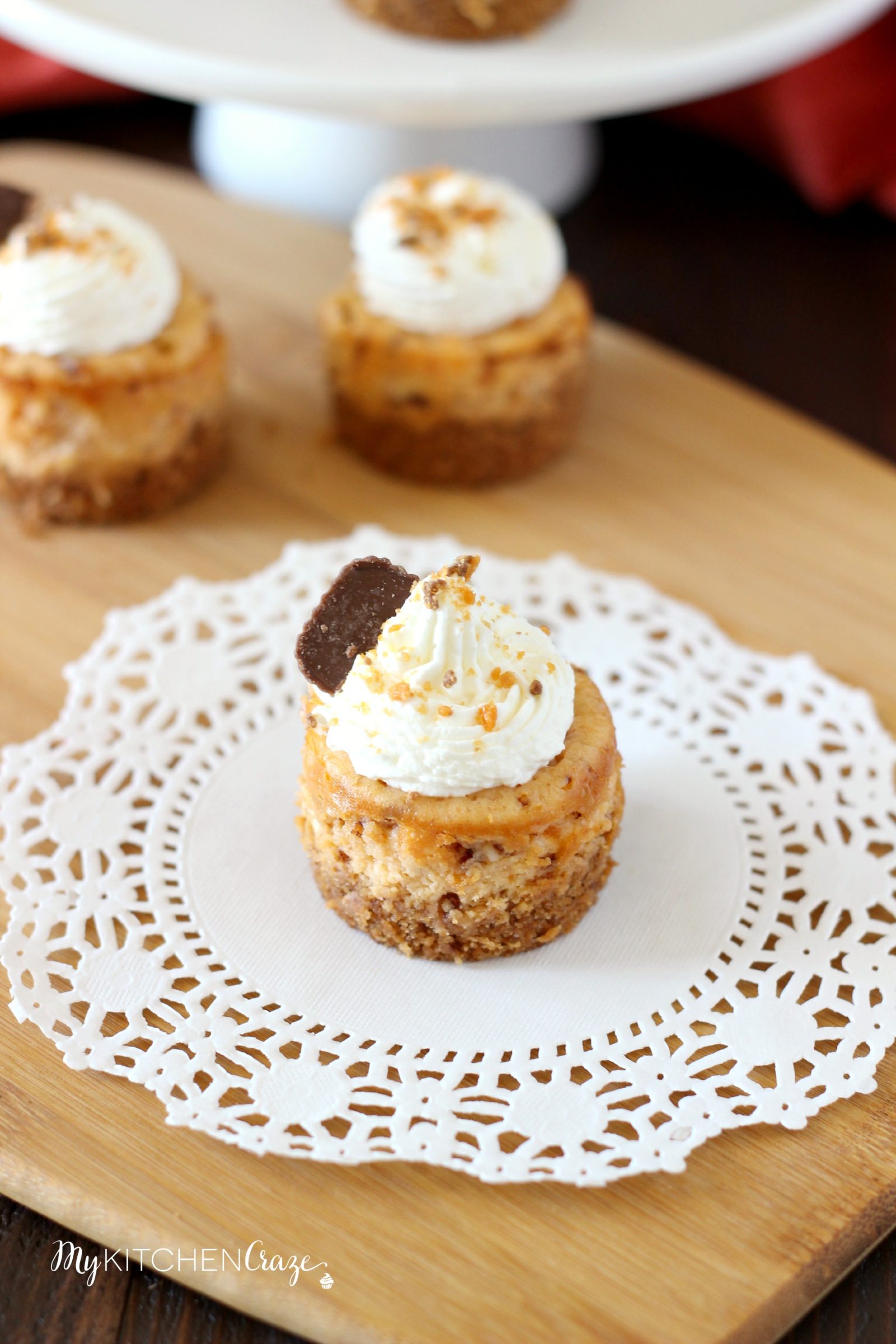 Mini Butterfinger Cheesecakes ~ mykitchencraze.com ~ Delicious cheesecakes swirled with butterfingers candies and topped with whipped cream! Yum!