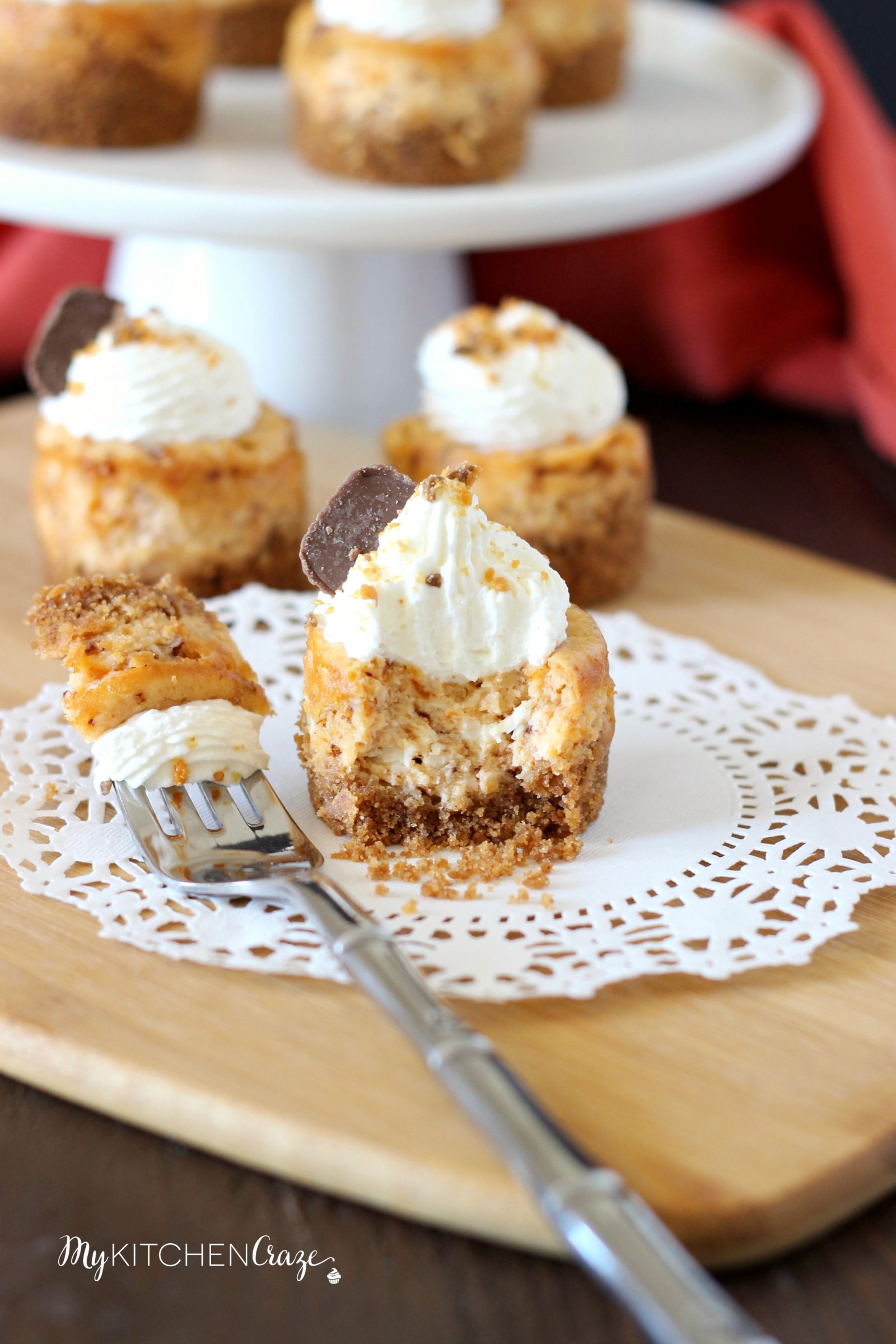 Mini Butterfinger Cheesecakes ~ mykitchencraze.com ~ Delicious cheesecakes swirled with butterfingers candies and topped with whipped cream! Yum!