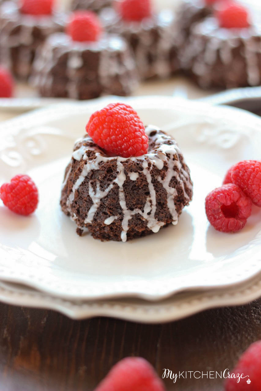Mini Chocolate Bundt Cakes ~ mykitchencraze.com ~ Moist chocolate cake topped off with a vanilla glaze and raspberry. Perfect for a special gathering or any occasion.
