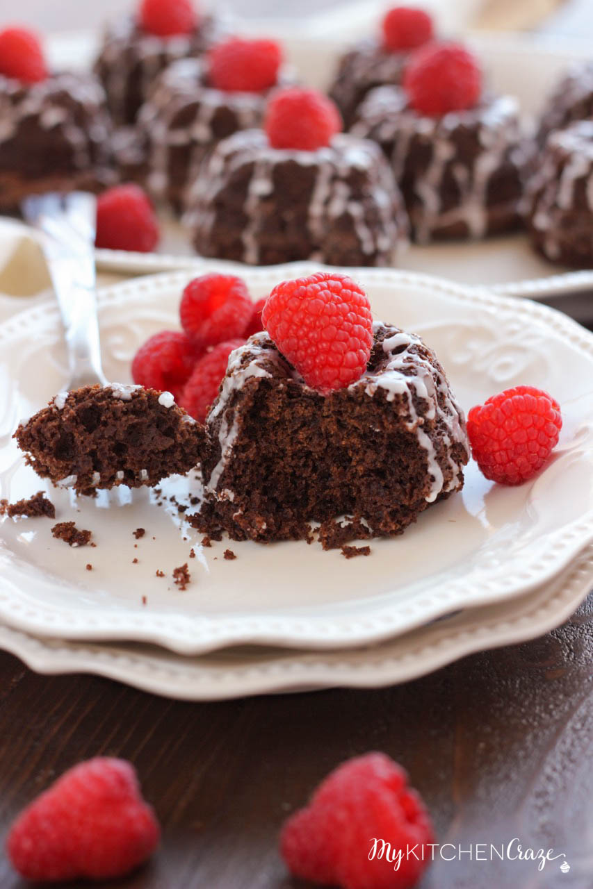 Mini Chocolate Bundt Cakes ~ mykitchencraze.com ~ Moist chocolate cake topped off with a vanilla glaze and raspberry. Perfect for a special gathering or any occasion.