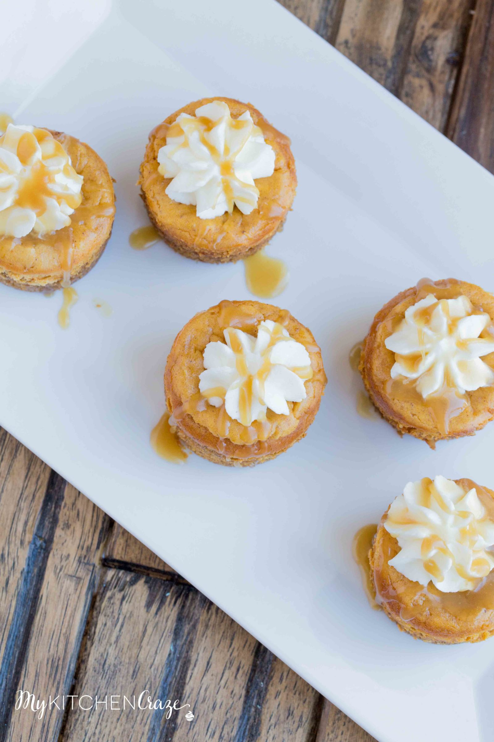 Mini Pumpkin Cheesecakes are the perfect fall dessert! Creamy cheesecake has the perfect hint of pumpkin, topped with homemade whipped cream and caramel sauce. It doesn't get much better than these cute mini cheesecakes this season!