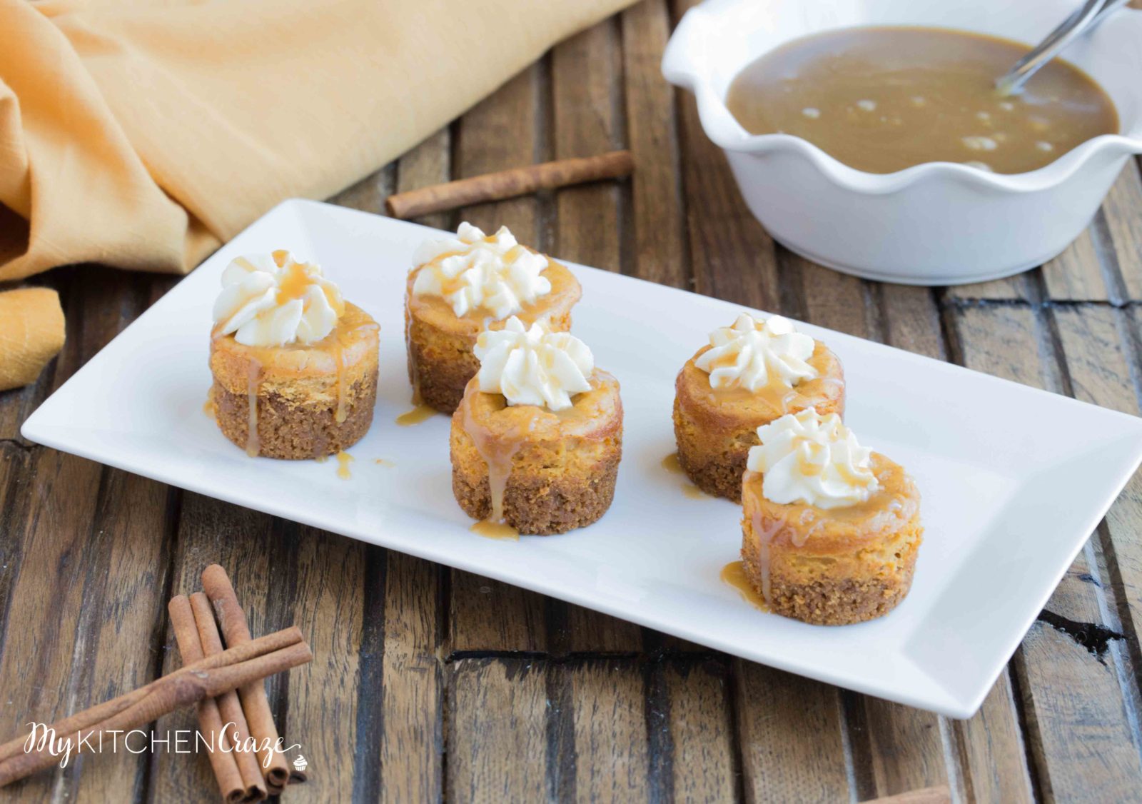 Mini Pumpkin Cheesecakes are the perfect fall dessert! Creamy cheesecake has the perfect hint of pumpkin, topped with homemade whipped cream and caramel sauce. It doesn't get much better than these cute mini cheesecakes this season!