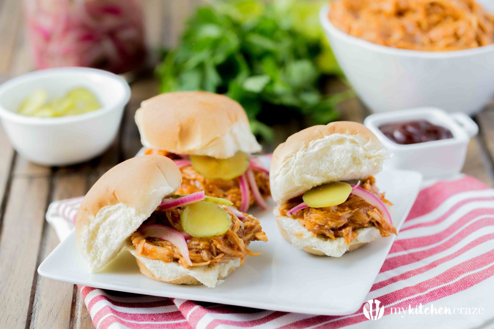 BBQ Pulled Chicken Sliders are packed with delicious flavor! The chicken is slow cooked with Barbecue sauce then shredded or 'pulled' and piled on top of slider rolls. Perfect for a busy night or a fun gathering! 